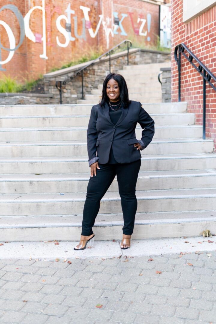 A woman standing on some steps wearing black pants and shoes.