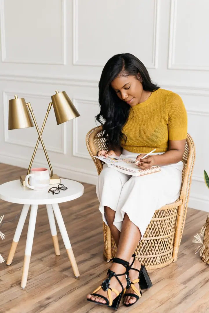 A woman sitting in front of a table with two lamps.