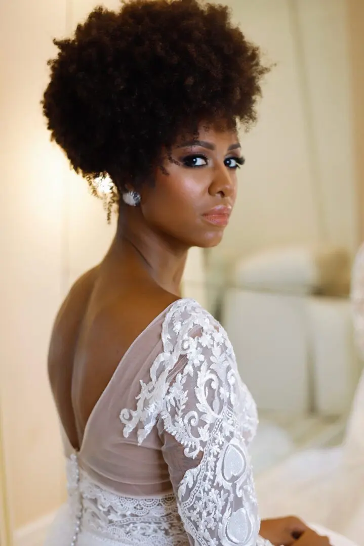 A woman with an afro in a white dress.