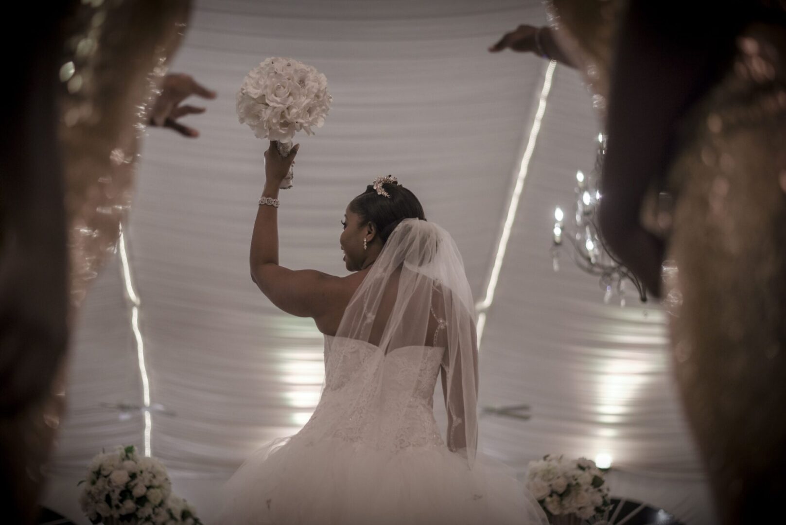 A bride holding her bouquet up in the air.